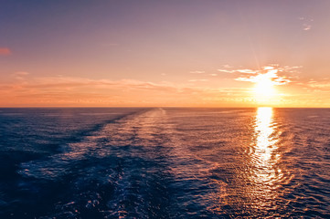 Sunset at sea with waterway of a cruise ship