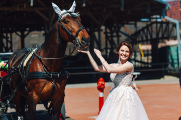 Fototapeta na wymiar beautiful bride posing along with a horse on the street