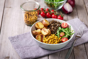 Healthy dinner with baked potatoes, green asparagus and spicy chickpeas, avocado, arugula, vegan, vegetarian food