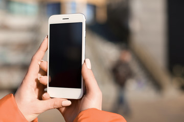 Woman with mobile phone outdoors, closeup