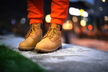 Young woman in winter shoes on street at night