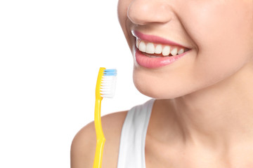 Young woman brushing her teeth on white background, closeup