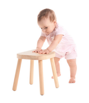 Cute Baby Holding On To Wooden Stool On White Background. Learning To Walk