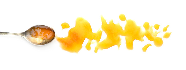 Spoon and sweet jam on white background