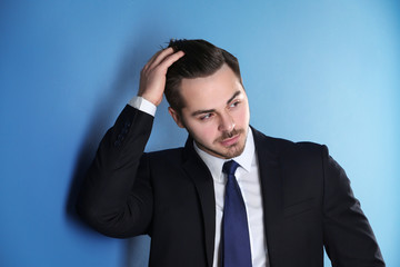 Portrait of young man with beautiful hair on color background