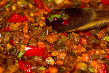 cooking a roast for soup of onions, carrots, paprika, tomatoes, herbs and spices in sunflower oil in a frying pan