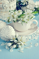 Fototapeta na wymiar Romantic composition with tea cup, zephyr and apple flowers 