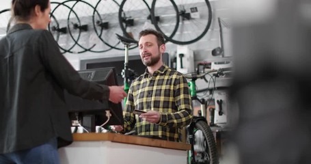 Small business owner serving customer in a bicycle store - Powered by Adobe