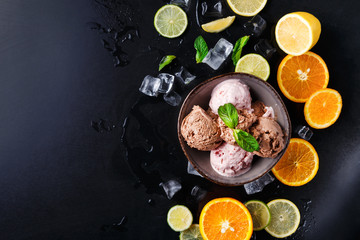 Fototapeta na wymiar Ice cream scoops in bowl on black background