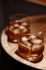 Glass of whiskey on wooden background close up
