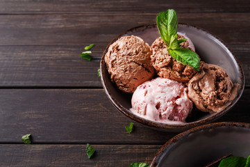 Portion of ice cream scoops with fruit on wood