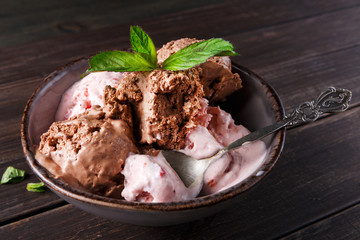 Portion of ice cream scoops with fruit on wood