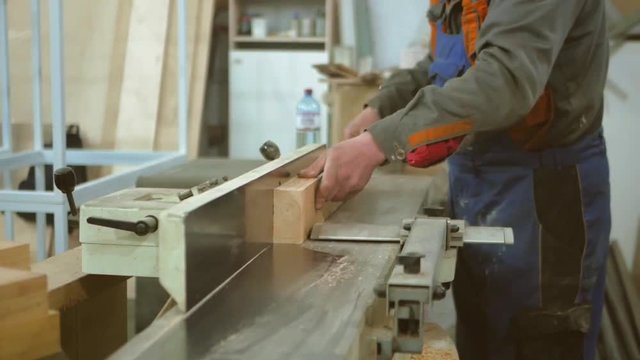 The carpenter scribes the board on a white jointing machine