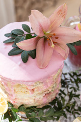 Tasty pink cake on a dessert table at a baby shower party for a girl