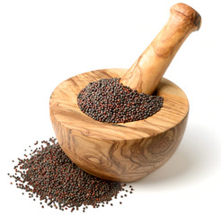 dried canola seeds in the olive wooden mortar, isolated on white