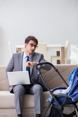 Businessman looking after newborn baby at home and teleworking