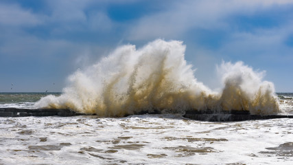Storm at Black sea coast in Odessa, Ukraine. Huge waves are crashing and spraying ashore during sunny day