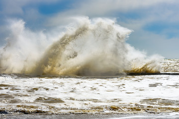 Storm at Black sea coast in Odessa, Ukraine. Huge waves are crashing and spraying ashore during sunny day