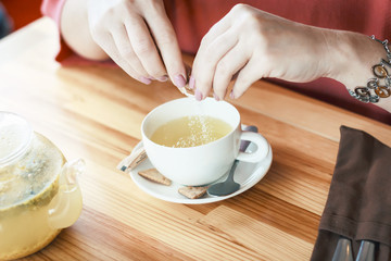 Female hands with a cup of hot tea to sip a medicine for colds and fever. aromatic drink,   Treatment and prevention of grip and viral colds