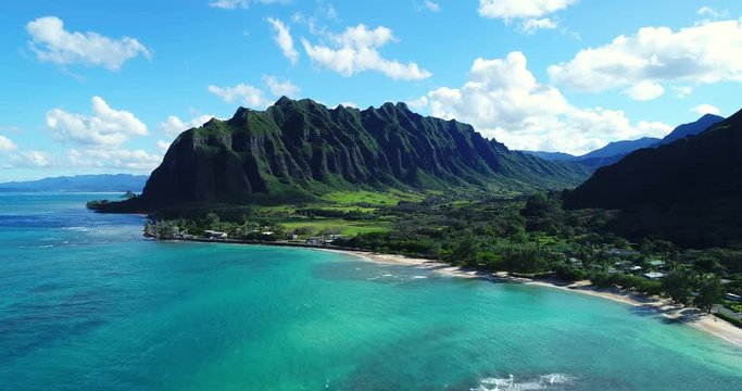 Aerial view flying towards lush jungle mountain landscape on the east side of Oahu in Hawaii 