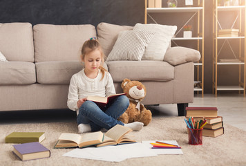 Little girl with book and her favorite toy at home