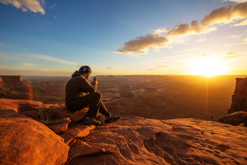Fototapeta premium Hiker meets sunset at Grand view point in Canyonlands National park in Utah, USA