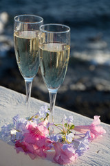 Two glasses with champagne or cava served outside on terrace, luxury resort with sea view, romantic vacation