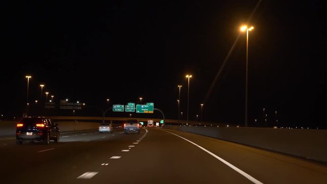 Night driving POV on a multi lane highway in a city