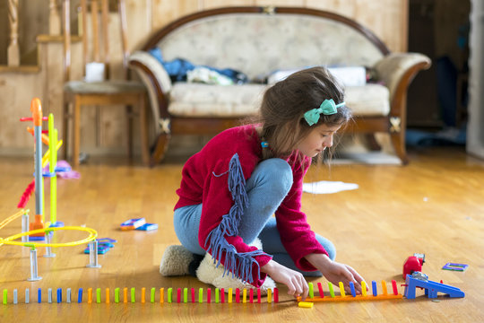 Girl 8 years old is played in the room with toys