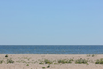 A deserted beach on the edge of the Earth, a clear sea on a summer day, an empty beach and a clear sky, a minimalistic landscape near the ocean, a copy of the space, rest on a deserted island