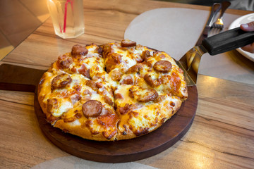 pizza with bacon ham and sausage on wooden table