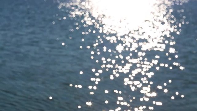 Beautiful view of blue shiny blurry sea. Sun reflection on calm surface of water. Slow motion hd video footage.