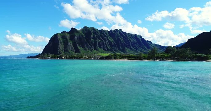Aerial view flying towards lush jungle mountain landscape on the east side of Oahu in Hawaii 