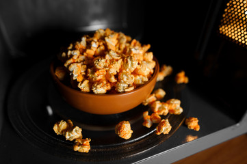 Obraz na płótnie Canvas roasted popcorn in a clay brown dish stand in the microwave