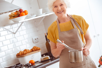 Handsome happiness housewife whisks eggs on a sponge cake
