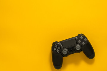 black gamepad on a yellow. Gaming concept