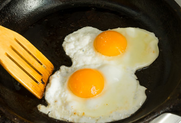 A couple of eggs for Breakfast. Fried eggs in a frying pan.