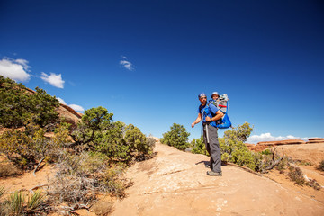 A family with baby son visits Arches National Park in Utah, USA