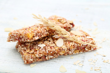 Tasty granola bars with wheat ears on wooden table