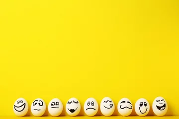 Fotobehang Eggs with funny faces on yellow background © 5second