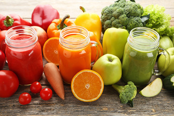 Vegetables smoothie in jars on wooden table