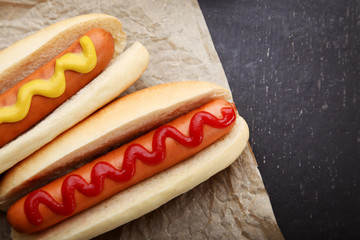 Hot dogs with ketchup and mustard on wooden table