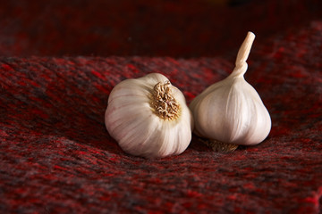 Garlic on a red textile. Food background. Garlics. sliced garlic, garlic clove, garlic bulb.