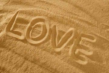 Love written in the sand on a beach