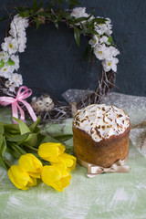 Vertically background with Easter’s cake and yellow tulip, nest of eggs, easter wreath