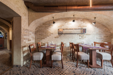 Brick wall and rustic tiled floor in restaurant interior