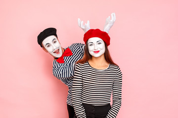Couple posing for photo. Man showinghorn sign, woman smiling