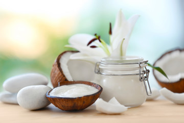 Composition with coconut butter in glass jar and shell on blurred background