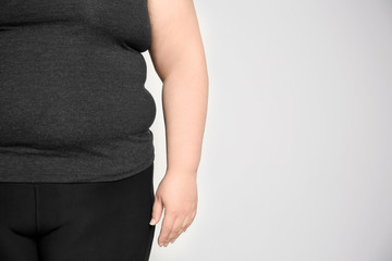 Overweight woman on light background