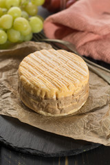 Tasting of oldest french AOC soft pudgent wrapped yellow cheese Livarot from Normandy, french cheese